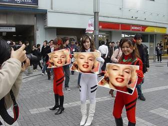 Fotomontaggio in cui tre ragazze asiatiche con cartelli con la tua foto, in strada, con grande anticipo.